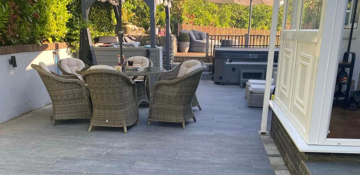 A patio with a table and chairs and an umbrella.