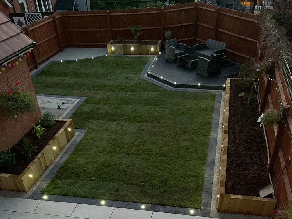 A small backyard with a lawn and lights.